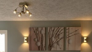 A modern living room with a brown leather sofa, a dark wooden coffee table, and wall-mounted artwork. - Boarders Inn & Suites by Cobblestone Hotels – Ashland City (Ashland City)