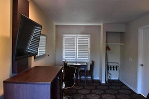 A compact room with a desk, chair, and a television mounted on the wall. - Country Inn (Santa Rosa)