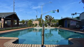Piscina com deck revestido, área de estar coberta e placa de rua indicando Santa Rosa Ave.
