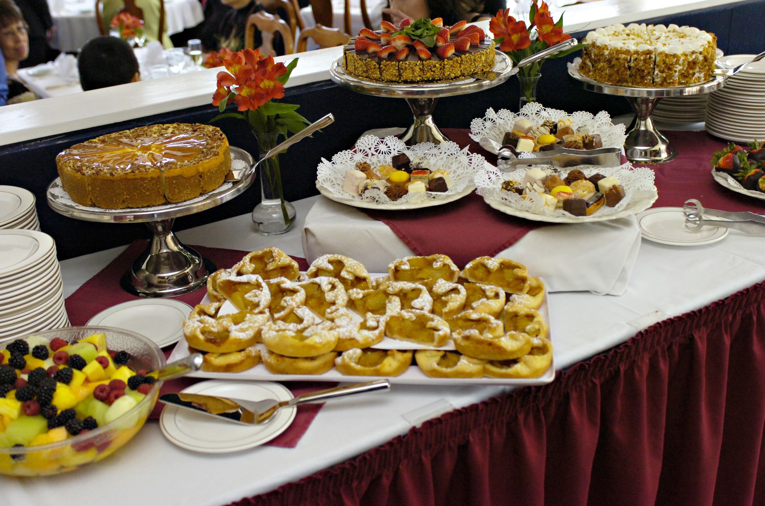 Ett bord med ett urval av desserter och frukter, upplagt som en buffé.
