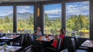 Un restaurante con amplios ventanales que ofrecen vistas a la montaña.