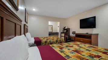 Una habitación de hotel con dos camas, televisión, escritorio y espejo.