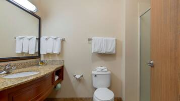Een badkamer met een wastafel, spiegel, toilet en handdoekhouder.