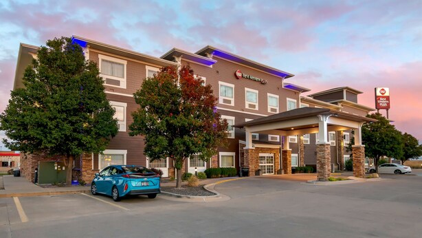 A hotel with a modern design, featuring a covered entrance and multiple windows.