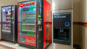 A row of vending machines, including a Coca-Cola ice cooler and a Coca-Cola dispenser.