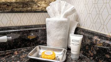 A bathroom counter with a soap bar, a towel, and a lotion tube.