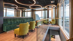 A modern interior with a green sofa, yellow chairs, and a wooden table. - Thon Hotel Panorama (Oslo)
