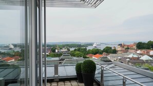 A high-rise building with a glass balcony overlooking a cityscape, including a river and historic buildings. - Thon Hotel Panorama (Oslo)