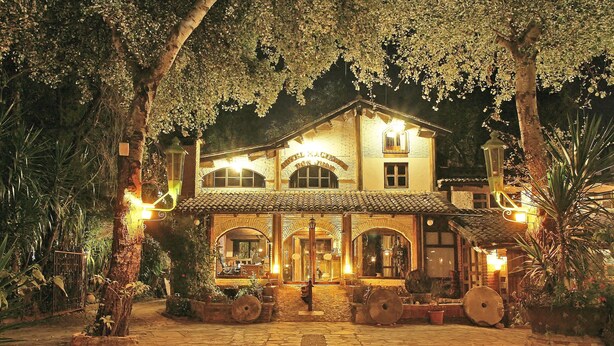 A traditional building with a tiled roof, arched windows, and a central entrance. - Hotel Hacienda Don Juan  (San Cristóbal de las Casas)
