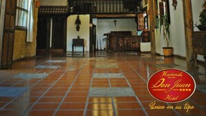A spacious hotel lobby with a high ceiling, exposed wooden beams, and a tiled floor. - Hotel Hacienda Don Juan  (San Cristóbal de las Casas)