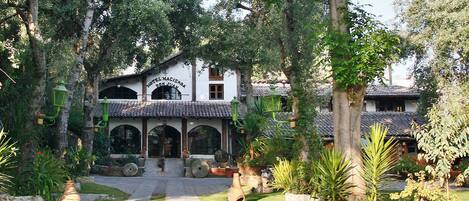 A traditional building with a tiled roof, arched windows, and a central entrance.