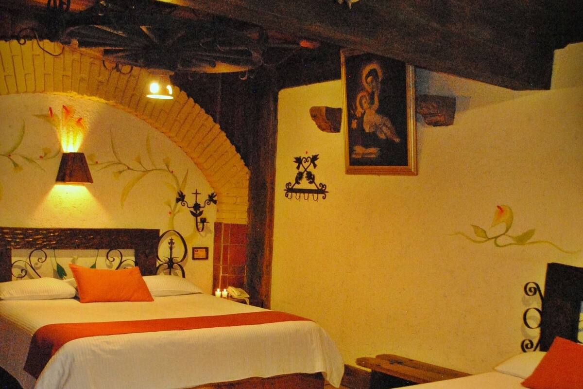 A hotel room with two beds, a wooden bench, and a tiled floor.