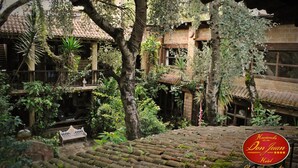 A courtyard with a traditional building, a bench, and a staircase. - Hotel Hacienda Don Juan  (San Cristóbal de las Casas)