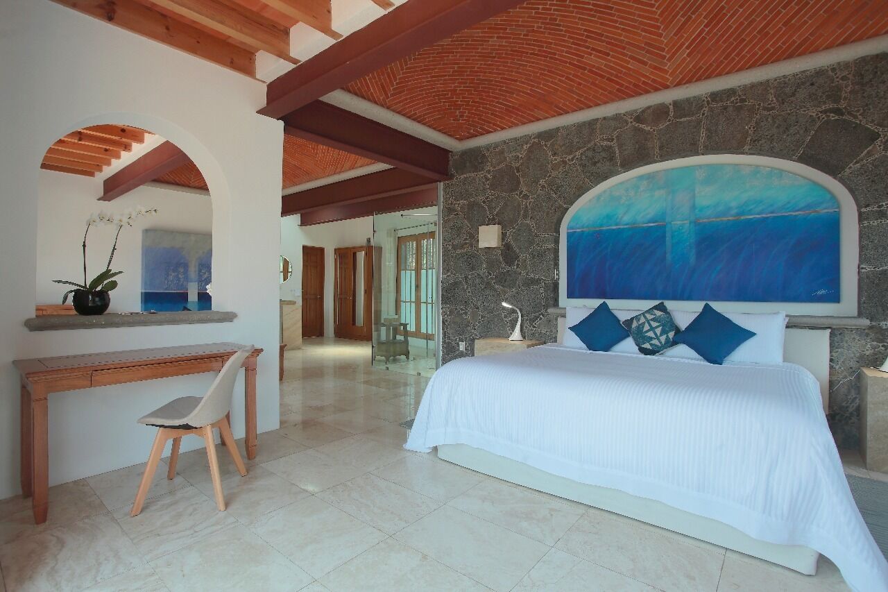 Quarto com cama, escrivaninha e cadeira.