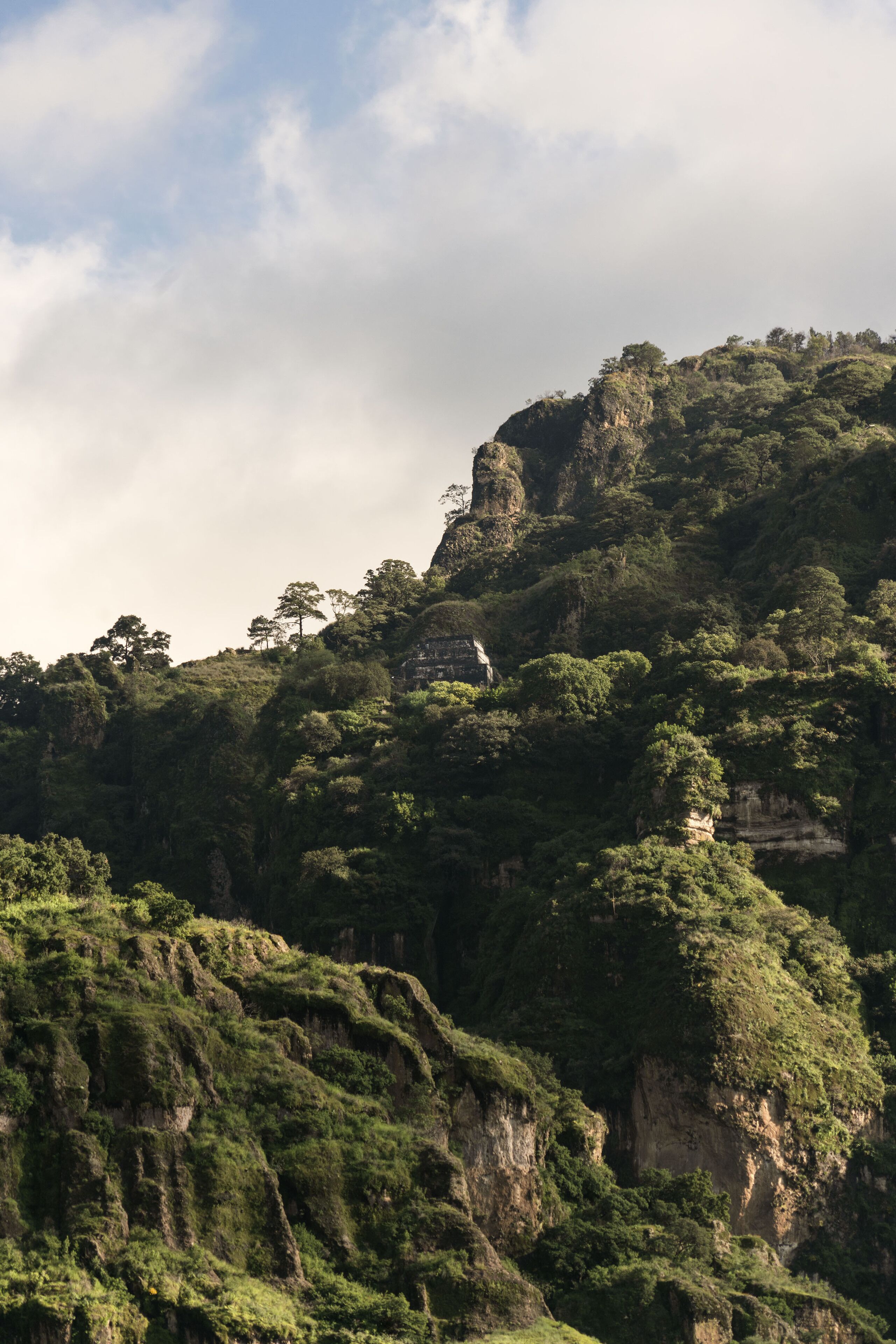Un paisaje montañoso con abundante vegetación y acantilados rocosos.