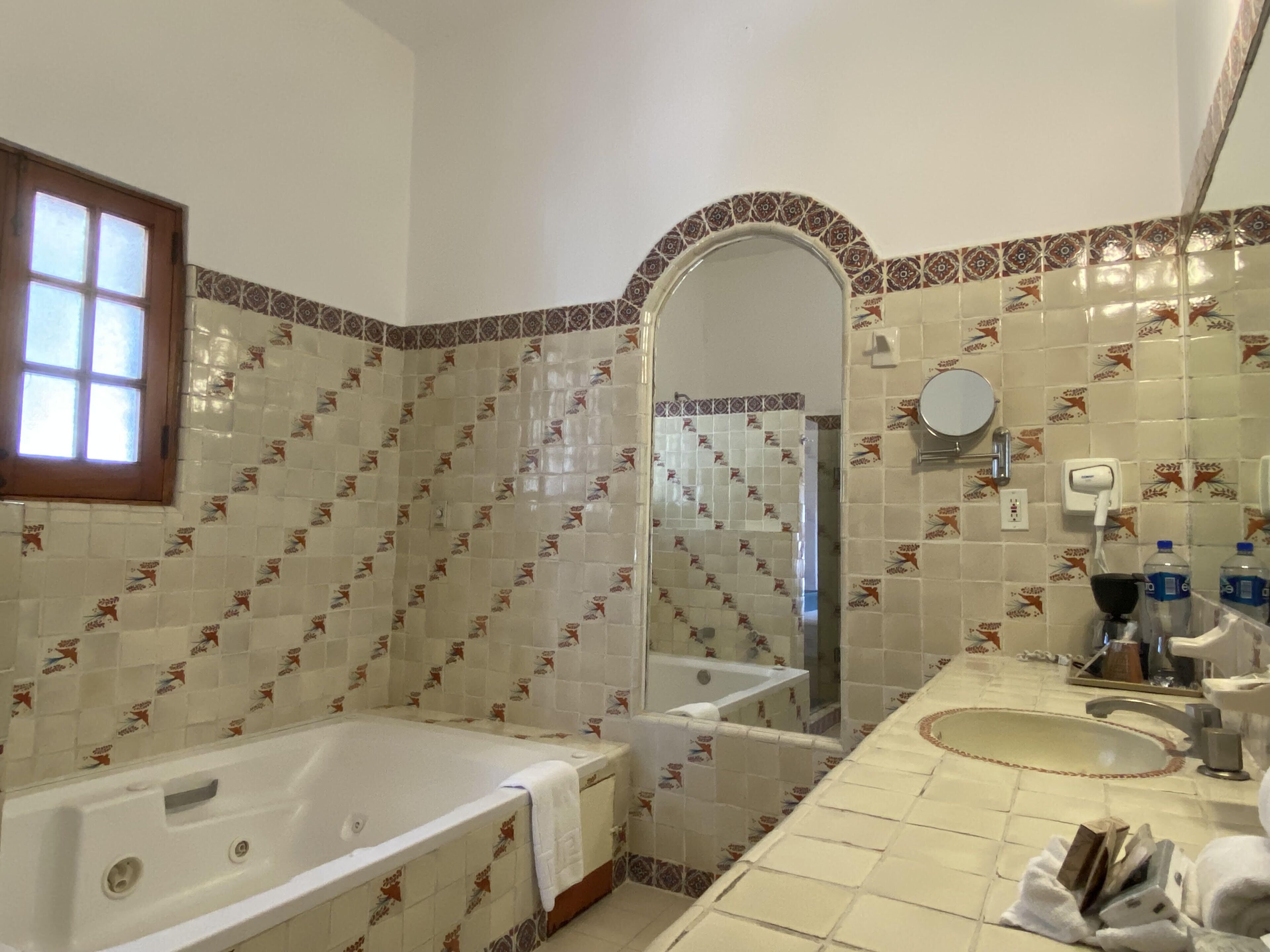 Un baño con bañera, lavabo, espejo y ducha.