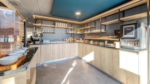 Una cocina moderna con armarios de madera, una cafetera y una variedad de utensilios de cocina en estantes.