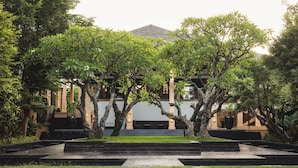 A building with a traditional architectural style, surrounded by lush greenery and a well-maintained garden.