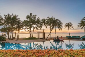 A poolside view with a sunset, palm trees, and a beach. - Mövenpick Asara Resort & Spa Hua Hin (Hua Hin)
