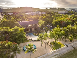 A resort with a swimming pool, palm trees, and a view of mountains. - Mövenpick Asara Resort & Spa Hua Hin (Hua Hin)
