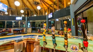 Zona de bar con varias grifas de cerveza, una barra y vistas del interior del restaurante.