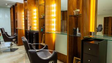 Un salón moderno con paneles de madera, vitrinas de cristal y sillas de peluquería negras.