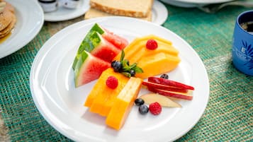 A plate of fruit including watermelon, mango, blueberries, raspberries, and apple slices.