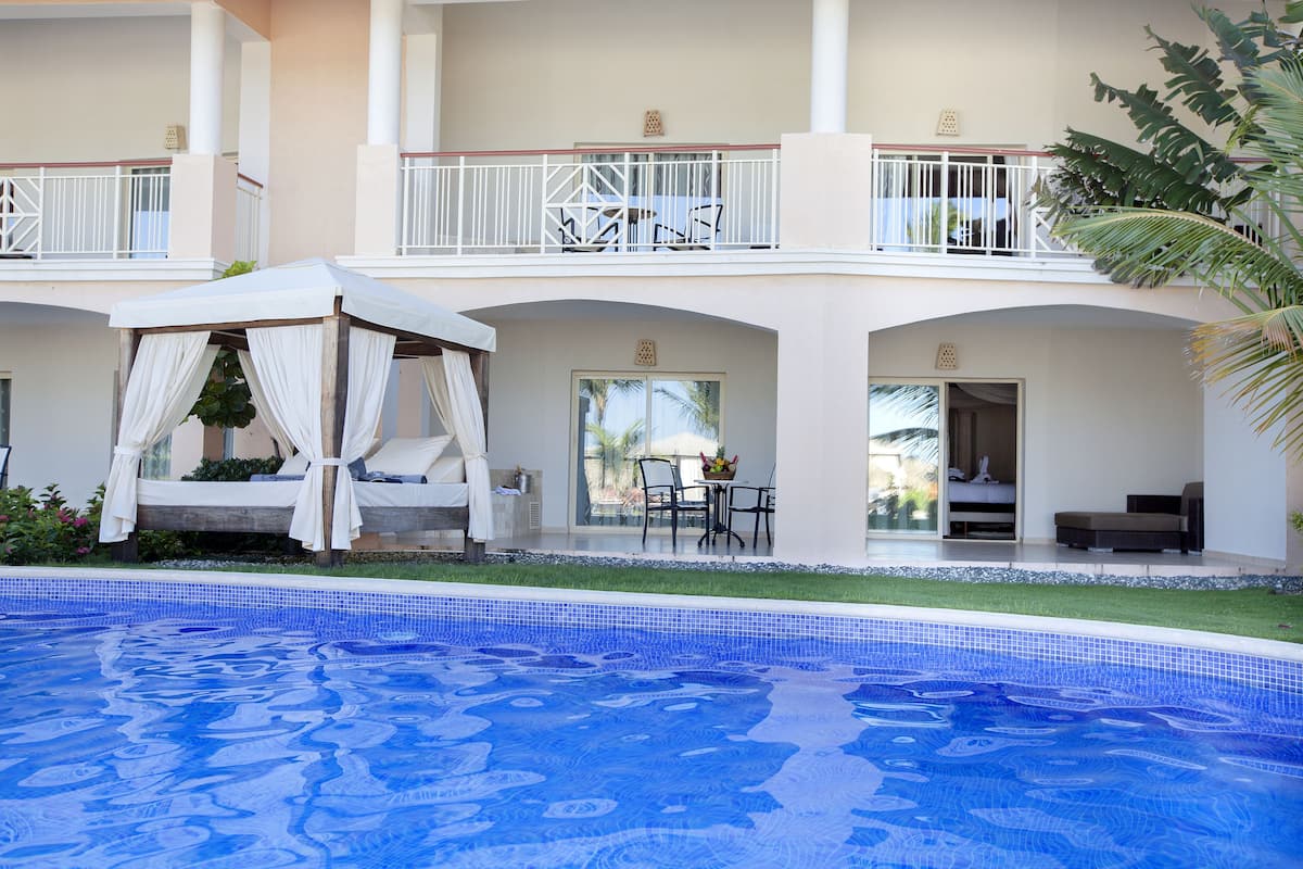 Ein Hotel mit Pool, Außenbereich und einer überdachten Pergola.