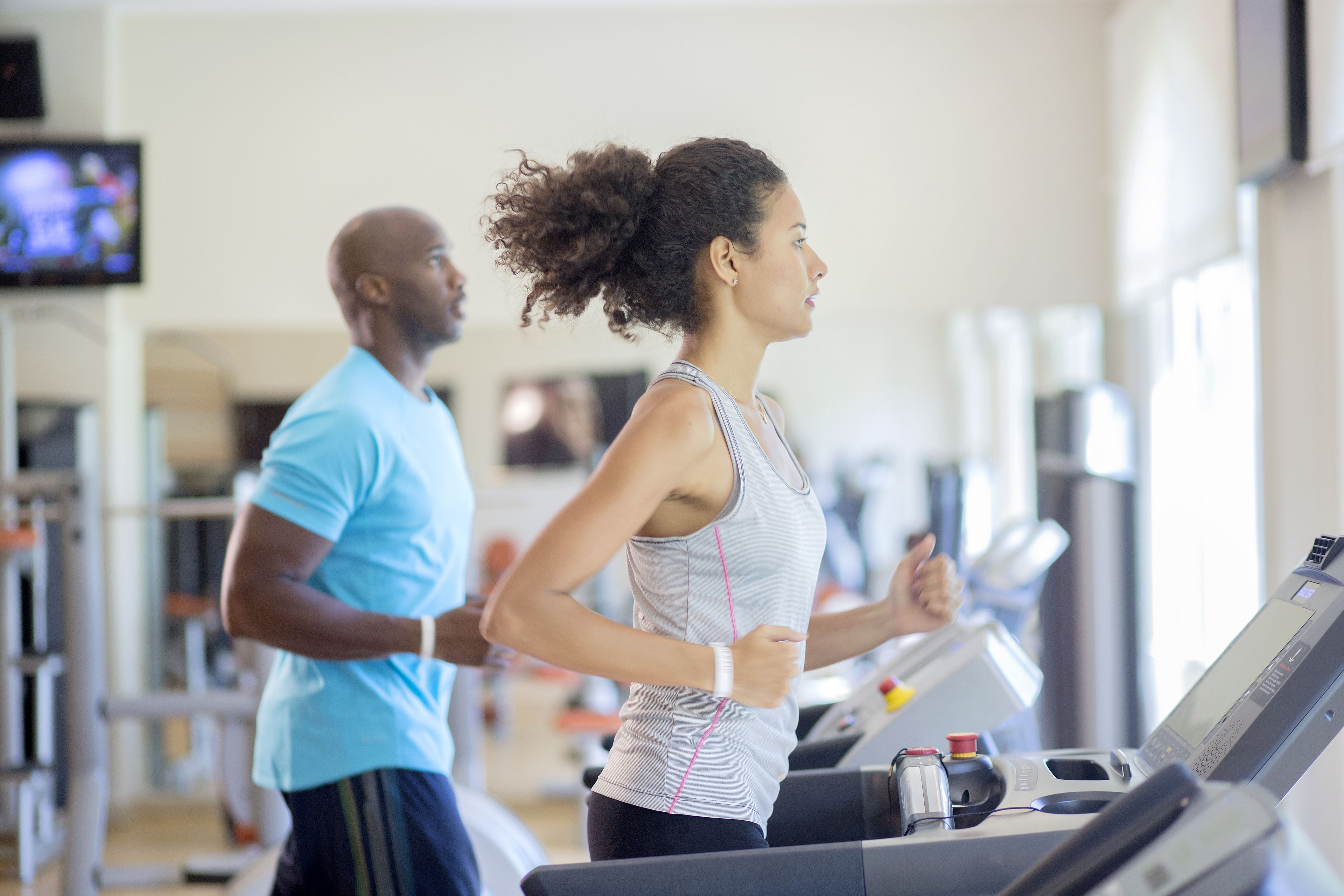 Un gimnasio con cintas de correr y equipo de ejercicio.