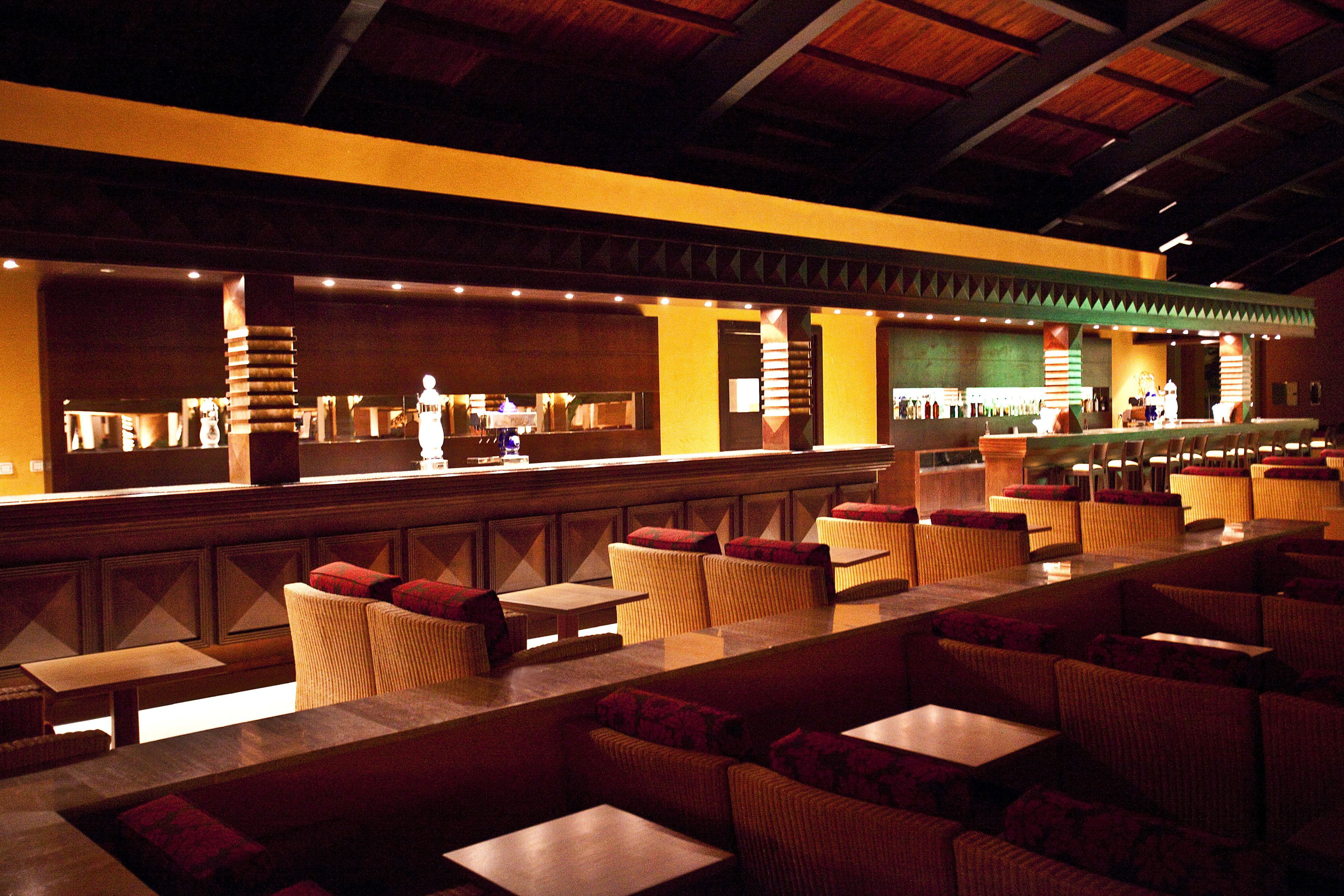 Un restaurant avec un long comptoir, des banquettes et des tables.