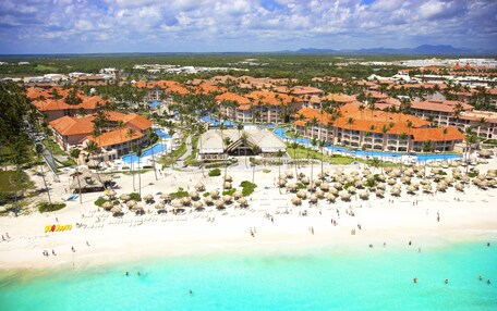 A resort with multiple buildings, a beach, and a pool area.