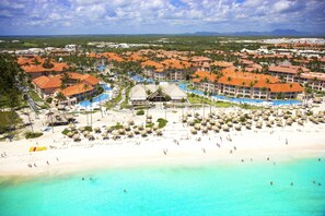 A resort with multiple buildings, a beach, and a pool area.