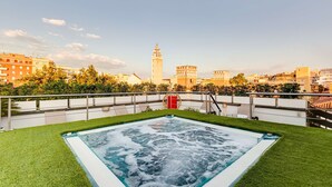 Una piscina en la azotea con vistas a una torre histórica y edificios circundantes.