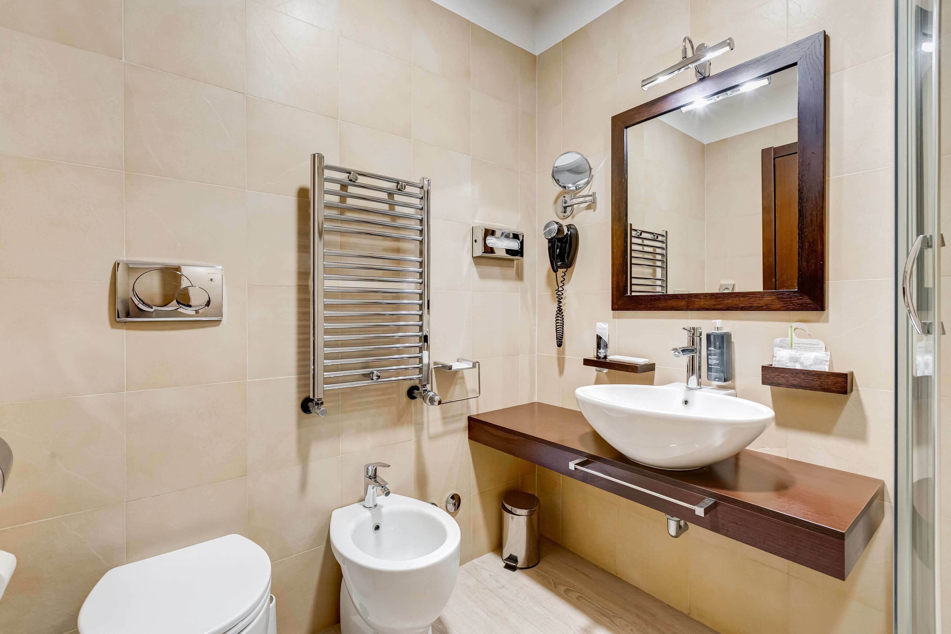 A modern bathroom with a bidet, a sink, a mirror, and a towel rack.