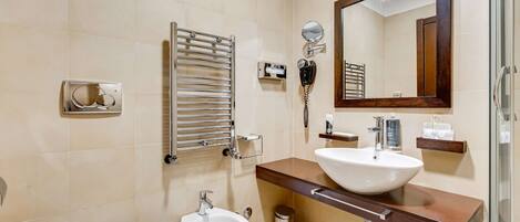 A modern bathroom with a bidet, a sink, a mirror, and a towel rack.
