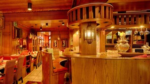 Ein gemütliches Restaurant mit Holzeinrichtung, Korbmöbeln und einer Bar.