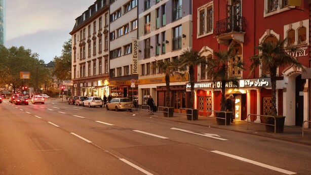 Ein Hotel mit mehreren Etagen, Balkonen und verschiedenen Geschäften im Erdgeschoss.