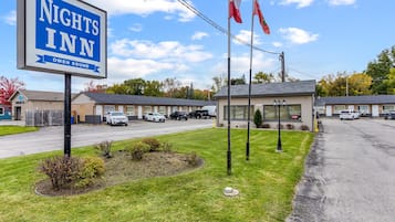 Um motel com uma placa que diz "Nights Inn Owen Sound" e algumas bandeiras.
