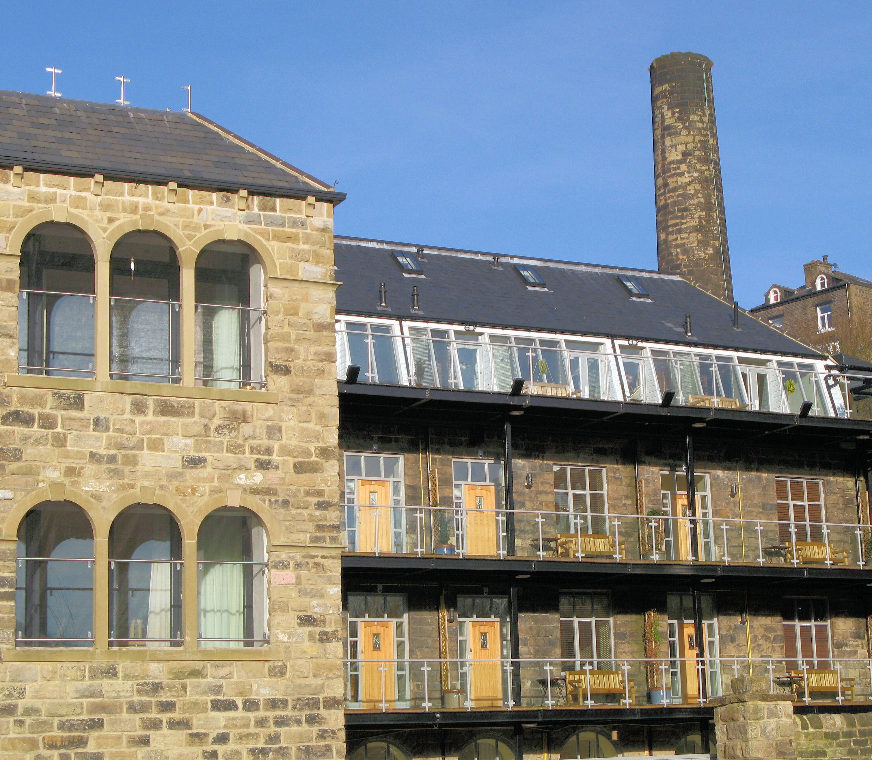A historic stone building with multiple windows and a flat roof.