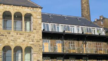 A historic stone building with multiple windows and a flat roof.