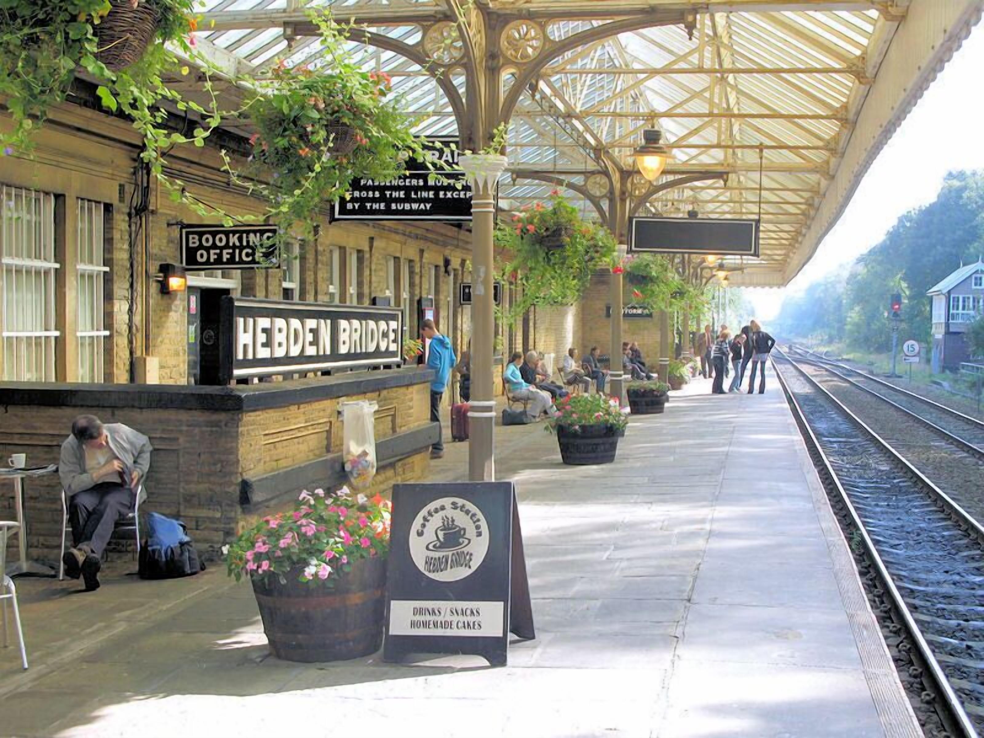 A train station platform with a booking office, a coffee station, and a sign indicating the Heiden Bridge.