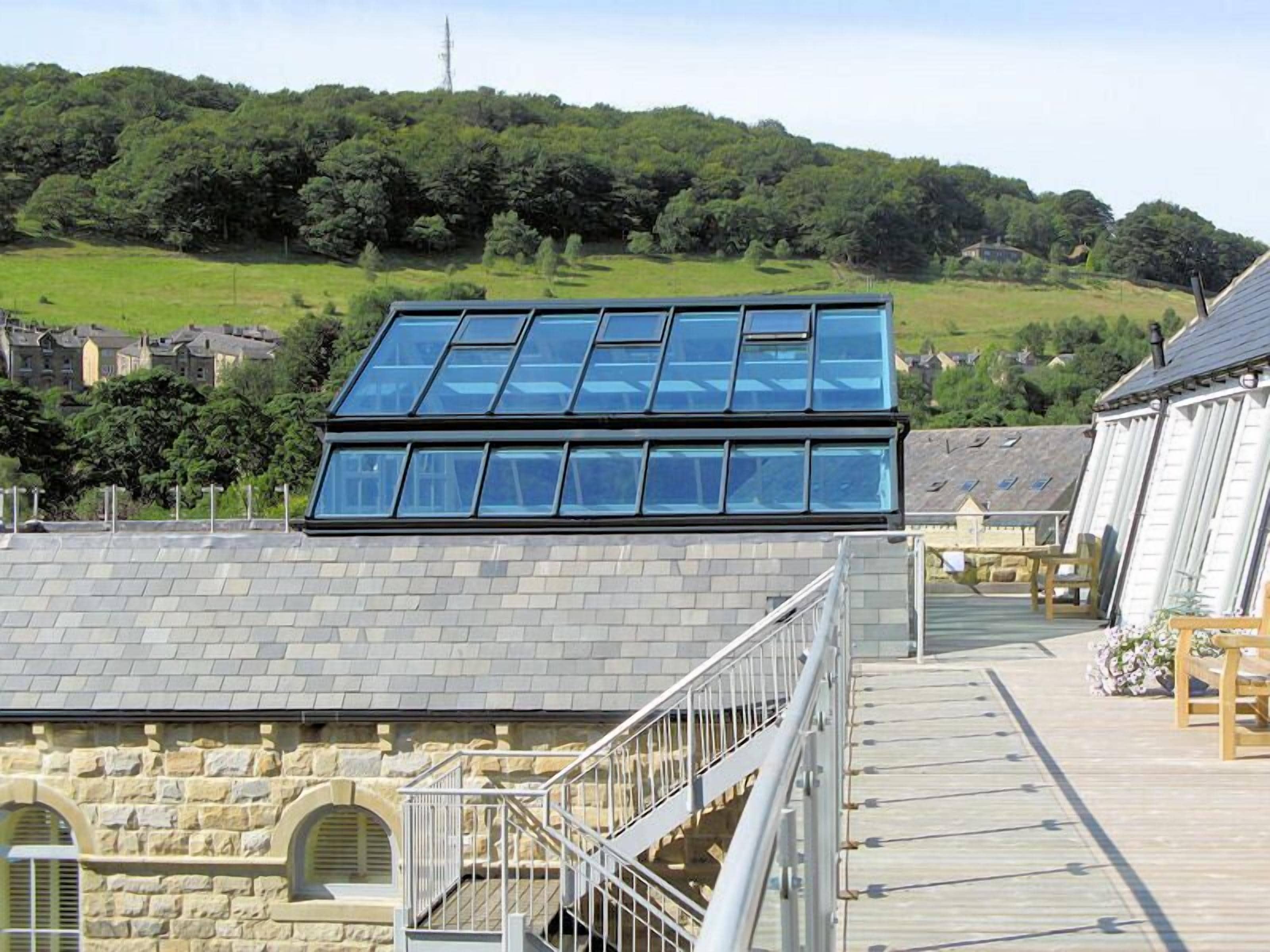 A building with a modern design, featuring a large glass roof and stone walls.