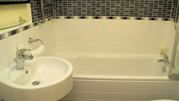 Un baño con un lavabo blanco, una bañera y un inodoro.