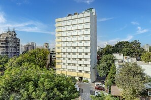 A multi-story hotel with a modern design, featuring a central entrance and a parking area in front. - Lemon Tree Hotel, Ahmedabad (Ahmedabad)