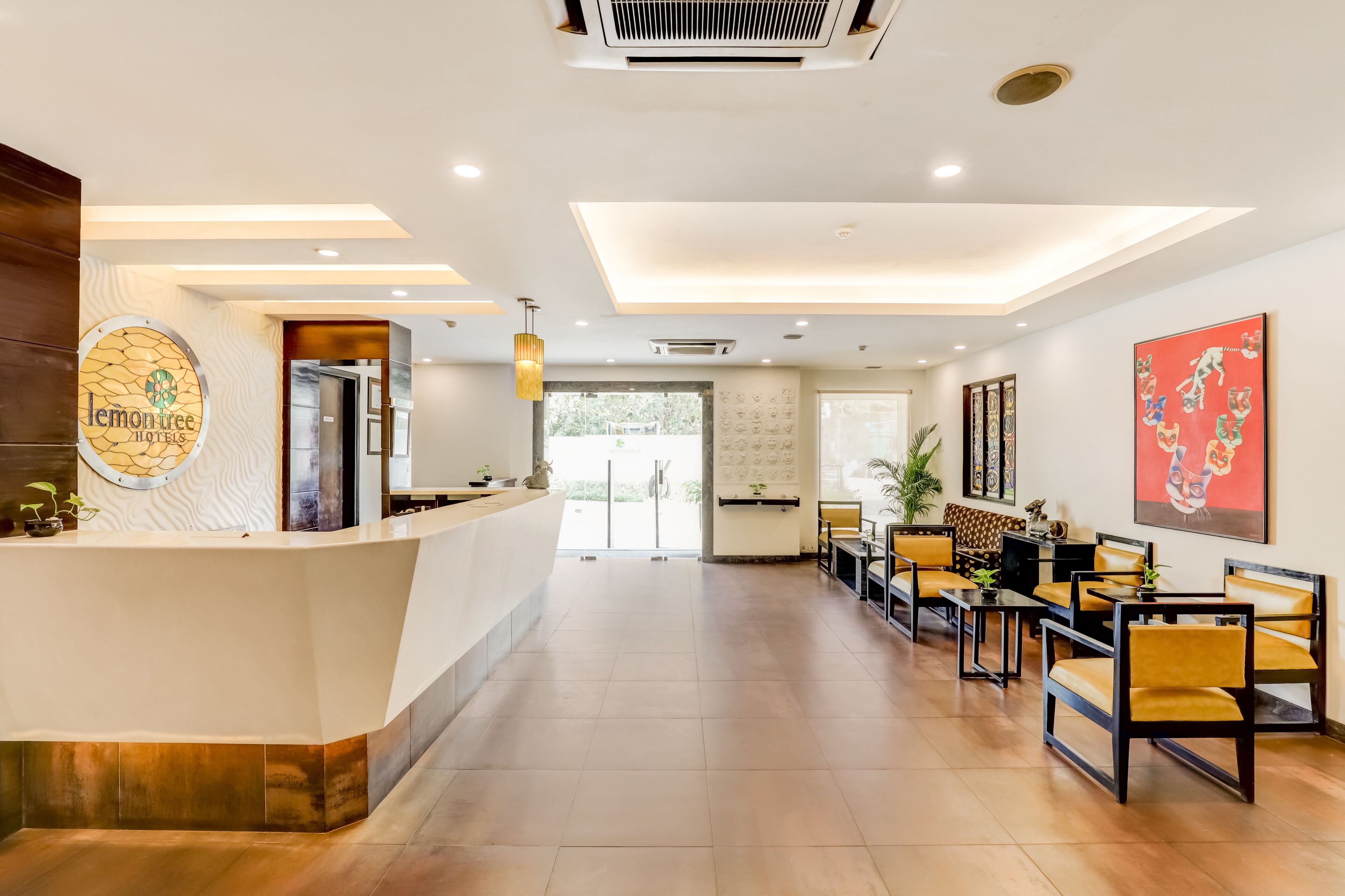 Uma área de recepção com design moderno, com balcão de atendimento, espaço de espera e obras de arte nas paredes.