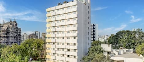 A multi-story hotel with a modern design, featuring a prominent logo on the top.