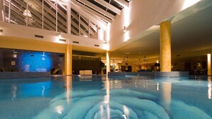 An indoor swimming pool with clear water, a ceiling with skylights, and a modern architectural design. - Grand Rose SPA Hotel (Kuressaare)