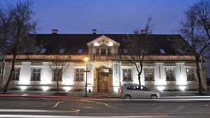 Un edificio histórico con fachada simétrica, ventanas grandes y una entrada central.