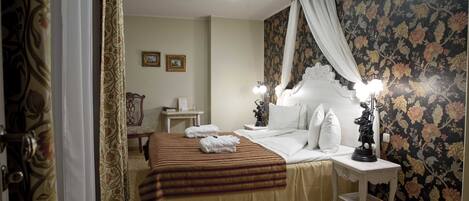 A hotel room with a bed, a nightstand, a chair, and a table.