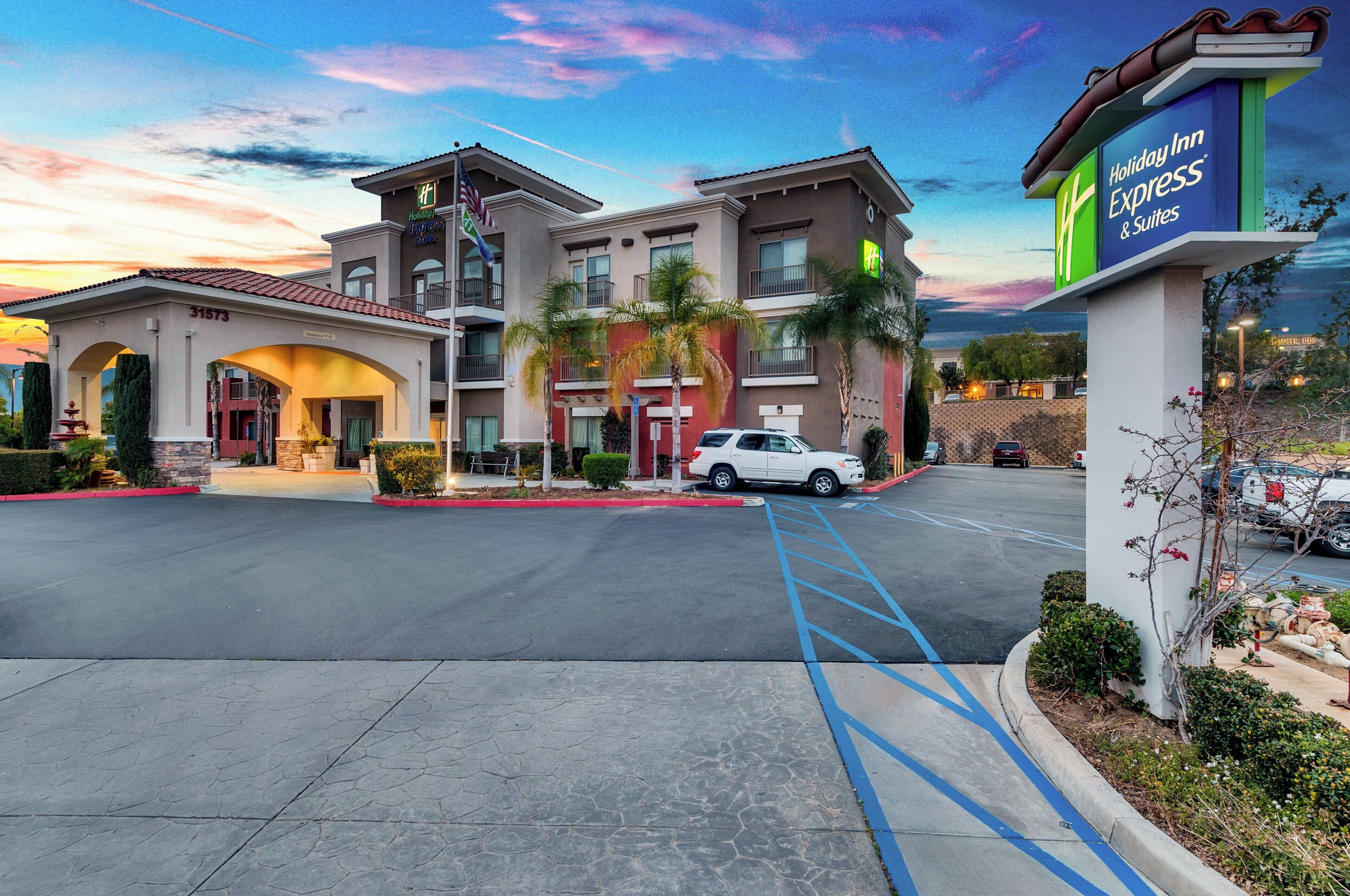 A Holiday Inn Express & Suites building with a clear sky and sunset.